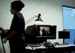 Grainy digital image of two people in an editing suite