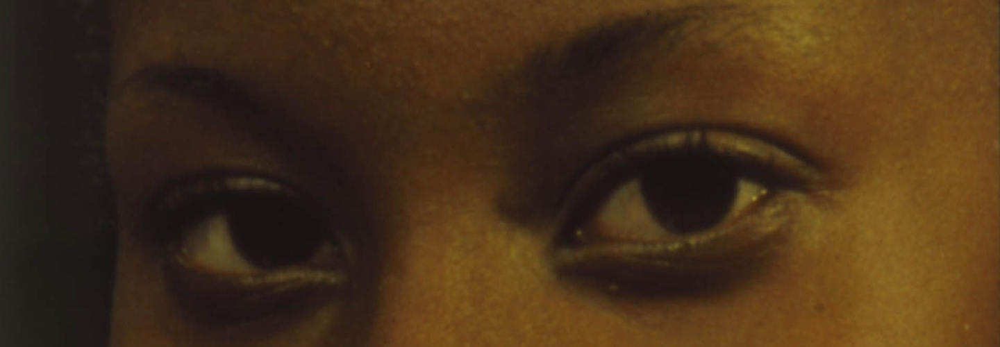 A woman's dark brown eyes locked into a direct gaze