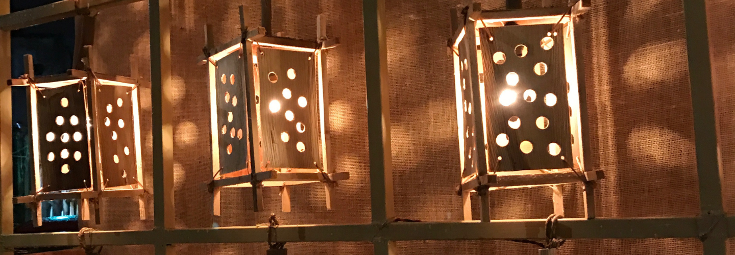 row of lit, rectangular lanterns with holes all over