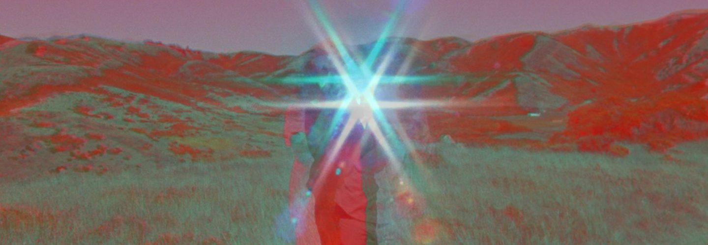 A figure, shown in red-blue anaglyph 3d, holds a reflective object in a landscape