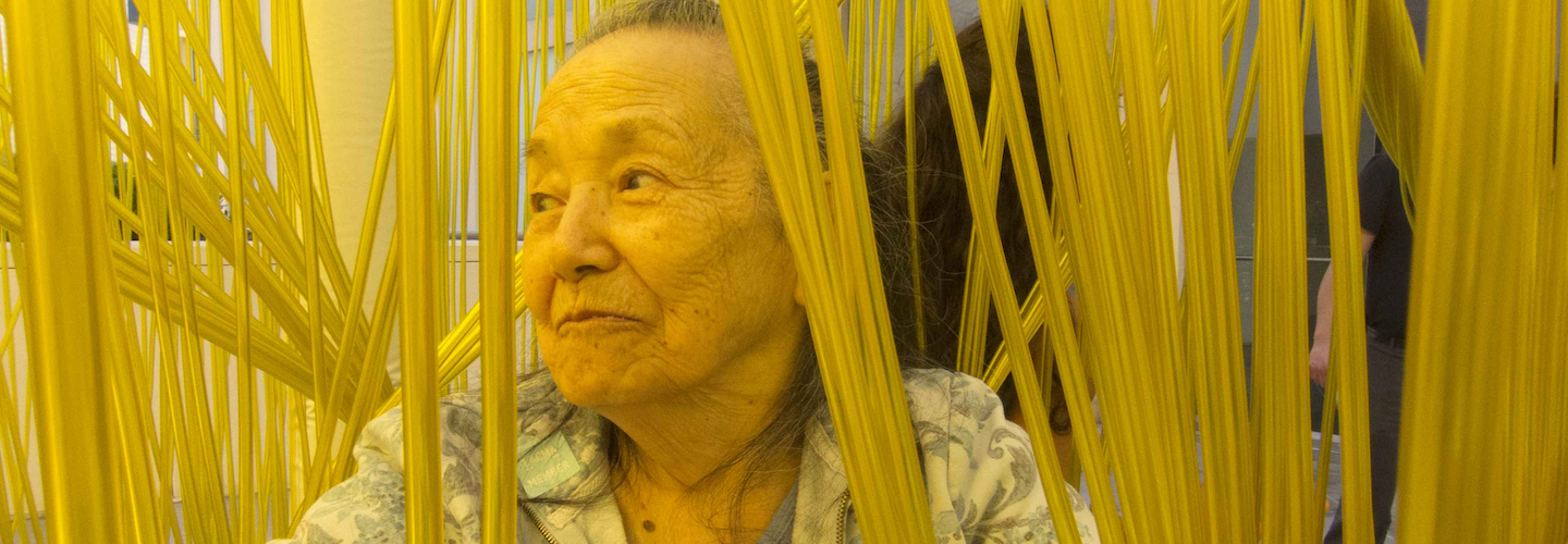 An elderly woman sits inside Jesús Rafael Soto's "Penetrable" sculpture