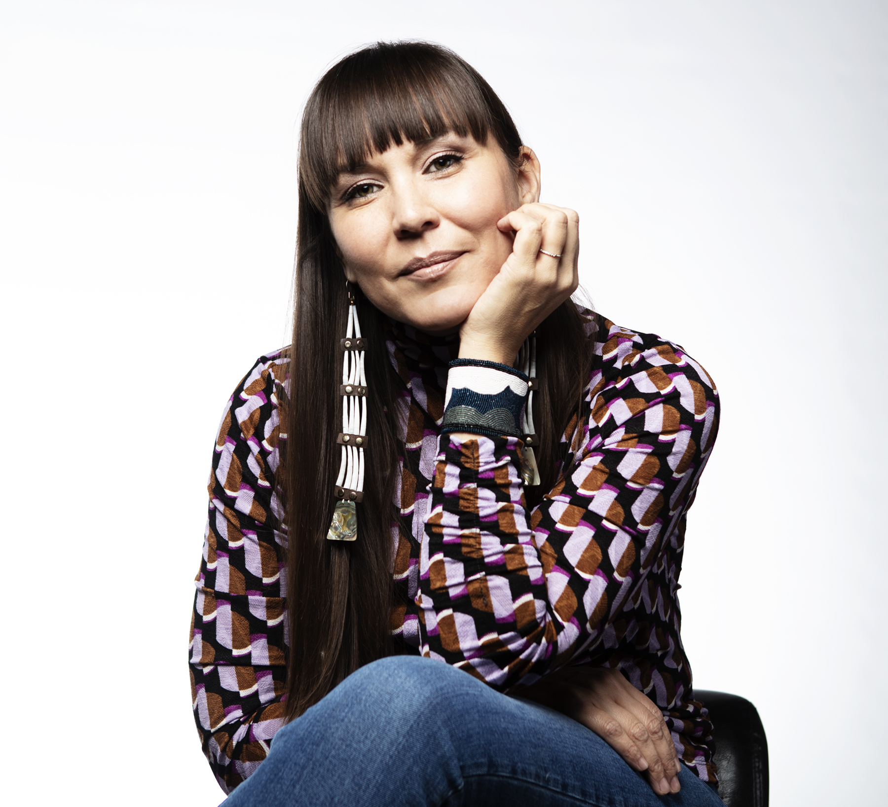 Chemehuevi woman with long brown hair, long earrings, and a patterned shirt