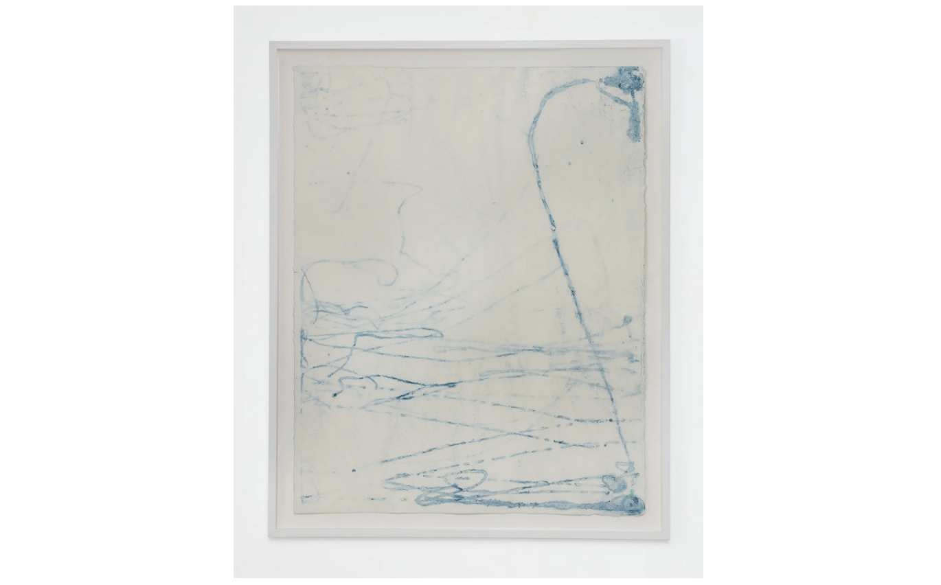 streaks of light blue ink crisscross on thick paper warped by water