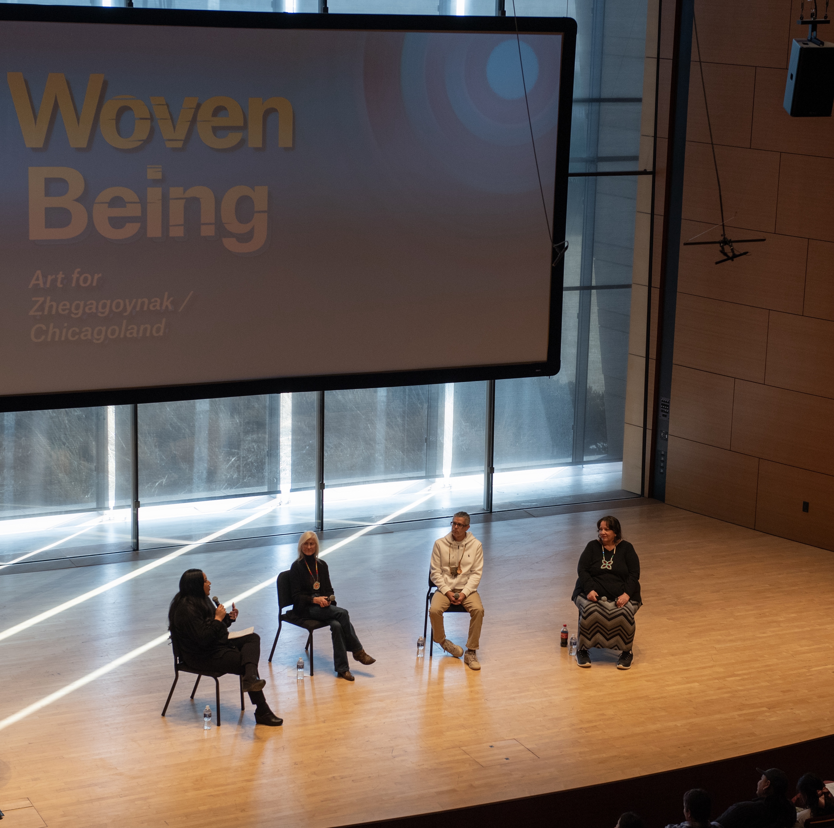 four people seated in chairs onstage 